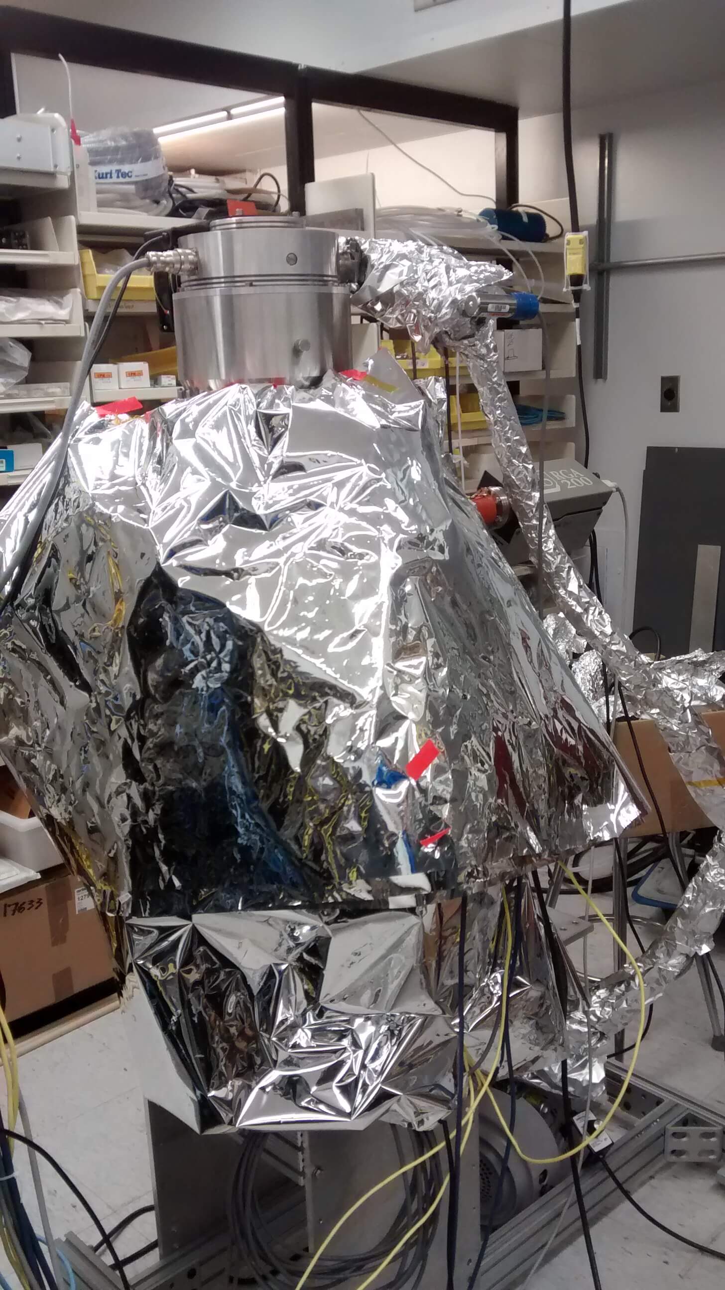 A picture of a vaccuum chamber wrapped in tin foil.